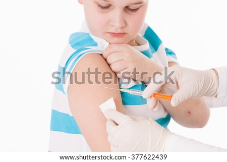Doctor giving a child injection in arm on isolated image.