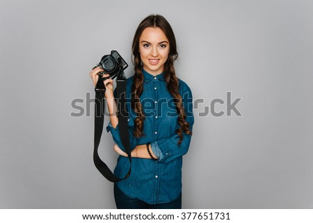 Attractive cute caucasian girl holding camera in her hand ready to make a selfie