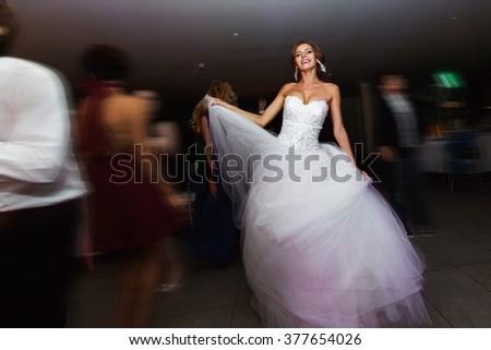 Smiling brunette bride dancing in the restaurant