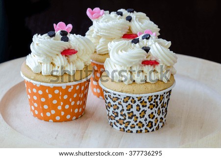 Cute cupcakes with vanilla cream in black background