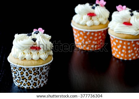 Cute cupcakes with vanilla cream in black background