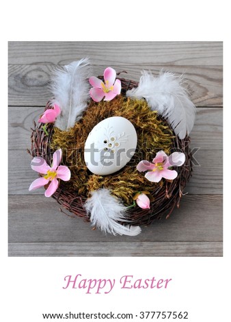 Homemade easter egg in nest on wood board. Holiday card.