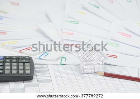 House with brown pencil and calculator on finance account have step of document with colorful paperclip place curve as background. Business and finance concepts rich and successful photography.