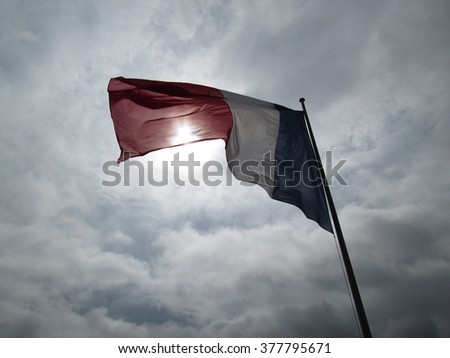 View of blowy French flag and storm gray sky