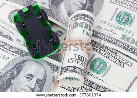 Car stands on dollar banknotes. cost of buying a car, fuel, insurance and other car costs