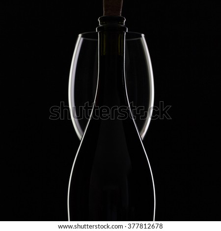Silhouette bottle and glass on the black background