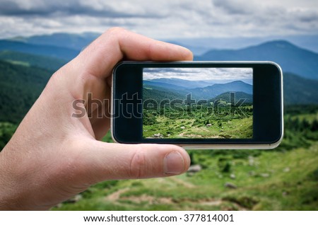 phone in hand man (photographing the landscape) photos from your phone, Self, photographing on the phone, the man photographs the mountain landscape on the phone (smartphone) side view