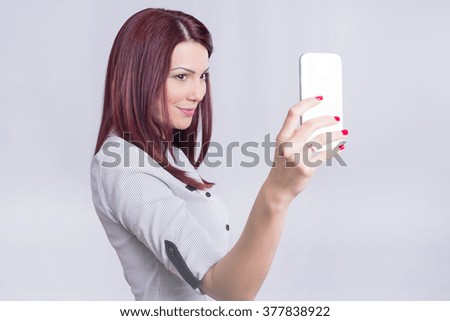 Redhead girl taking a photo of herself on a cell phone 