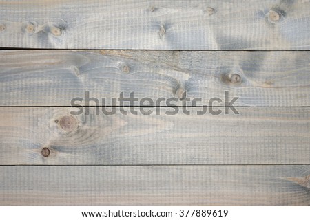 Varicolored cheap knotted weathered wood texture as background.