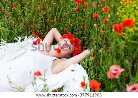a woman lying in a poppies flied