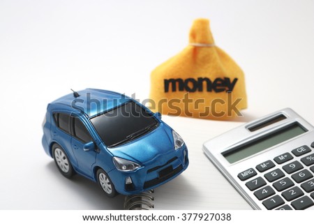 Toy car, money and calculator isolated on white background. Rent, buy or insurance car concept.