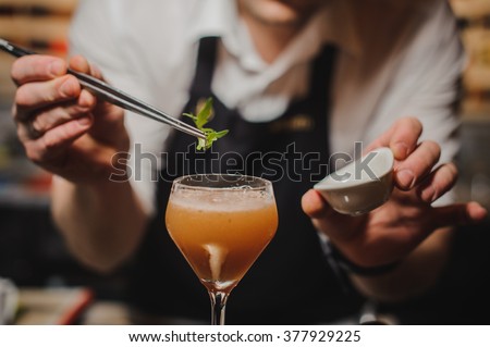 Barman is decorating cocktail with rocket no face Royalty-Free Stock Photo #377929225