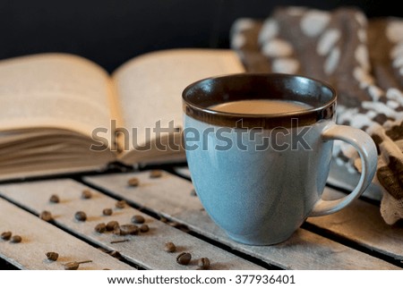 Cup of coffee with book and pink tulip on the table