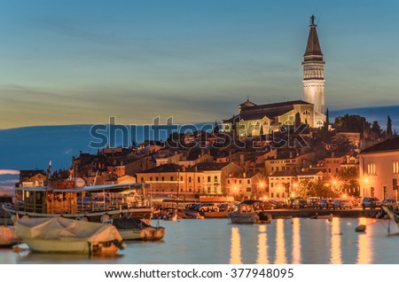 Evening in old Croatian city Rovigno (Rovinj), in Istria, night scene with water reflections and color full old buildings. Royalty-Free Stock Photo #377948095