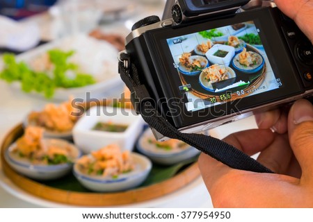 Hands taking photo vietnam food (banh beo) with camera mirrorless, Selective focus Royalty-Free Stock Photo #377954950
