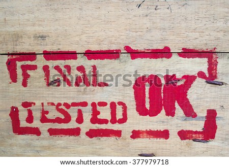 Text "final tested ok" on wood texture surface background.