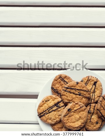 Crispy chocolate chip cookies on a rustic wooden table. Toned image.