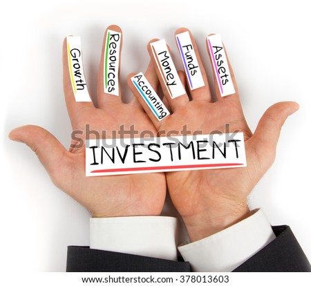 Photo of hands holding paper cards with INVESTMENT concept words
