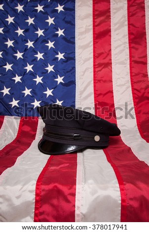 A police hat on an American flag background.