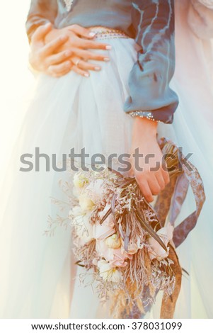 Oriental bride with bouquet in sunlight