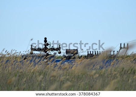 Oil well in the thickets of dry reeds. Oil well equipment.