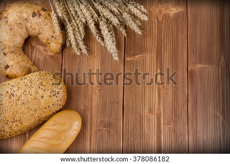 fresh bread and wheat on the wooden table background