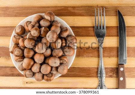 Hazelnuts background fork and knife,horizontal photo