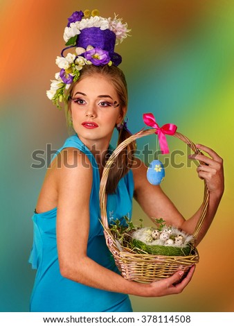 Woman with false eyelashes  and flowers in stylish hairstyle keep easter bunny.