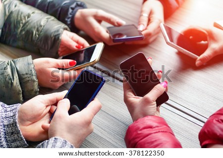 Group of friends having fun together with smartphones - Closeup of hands social networking with mobile cellphones - Technology and phone addiction concept - Soft focus on the left bottom hand Royalty-Free Stock Photo #378122350