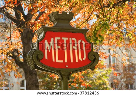 Parisian metro sign with autumn trees in the background