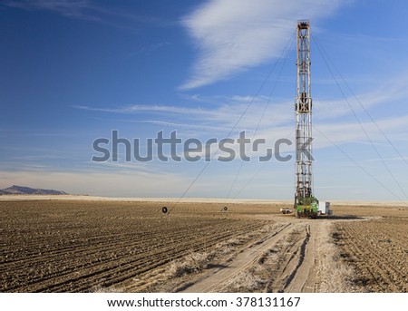 Fracking rig and road in a farmers field Royalty-Free Stock Photo #378131167