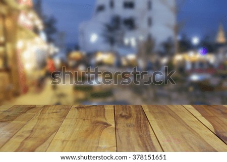 blurred image wood table and abstract people shopping at night market