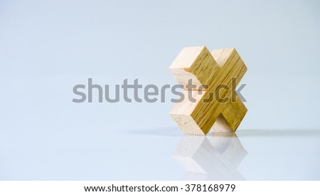 Single block wooden letter X or multiplication sign symbol. Isolated on empty background. Slightly de-focused and close-up shot. Copy space.