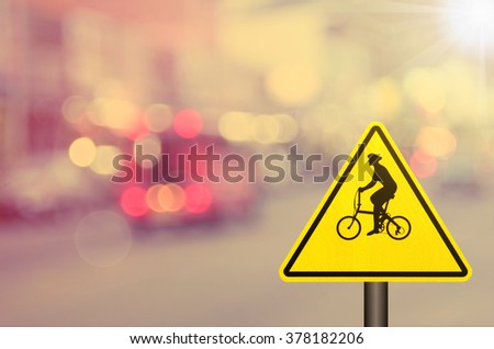 Bicycle sign on blur traffic road abstract background.Retro color style.