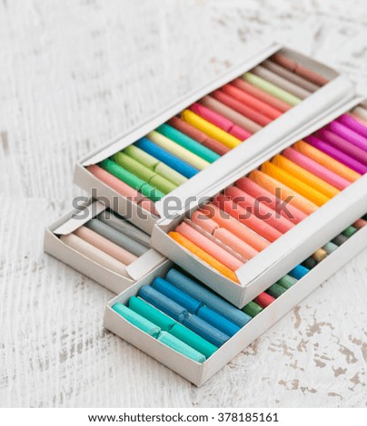 Colored pencils carnival in boxes on a light background vintage