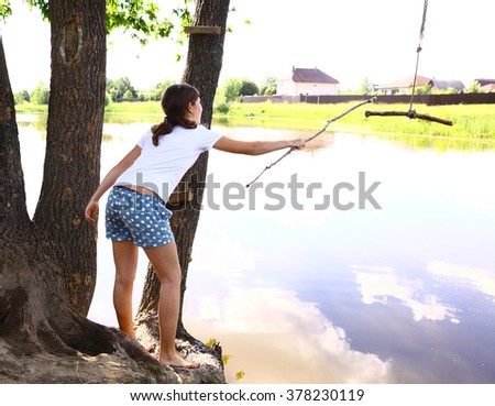 teenage girl prepare jump into the water with falling rope