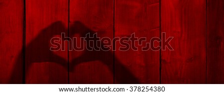 Concept or conceptual Valentine human man and woman hands silhouette as heart or love symbol on old red wood background, metaphor to romantic, romance, relationship, young, couple, wedding or lover