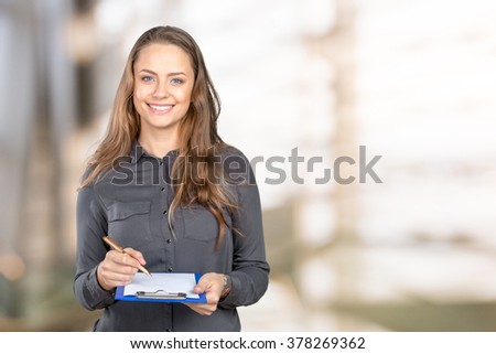 Woman takes notes on clipboard