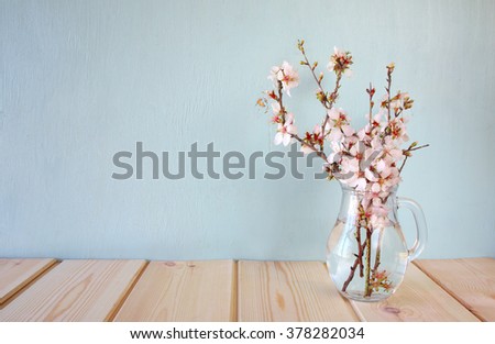 spring bouquet of flowers on the wooden table with mint background. vintage filtered image
