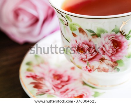 Beautiful bone china cup of tea with violet rose selective focus Royalty-Free Stock Photo #378304525