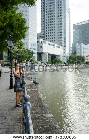 Outdoor summer smiling lifestyle portrait of pretty young woman having fun in the city in Singapore , take a photo around city  so excited.