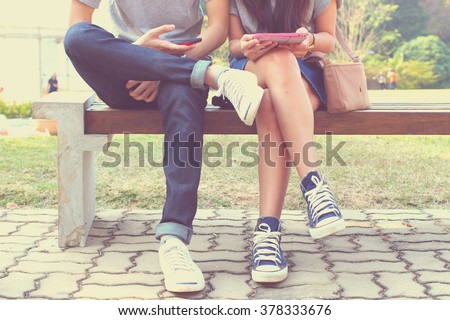 Close up of hipster couple in disinterest moment with smart phones in the outdoor, concept of relationship apathy and isolating using new technology and smartphone addiction Royalty-Free Stock Photo #378333676