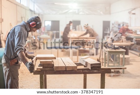 Man doing woodwork in carpentry. Carpenter work on wood plank in workshop Royalty-Free Stock Photo #378347191