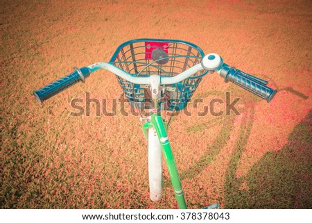 Detail of a Bicycle Handlebar Resting in vintage tone. Retro vintage bicycle at outdoor park with flowers on summer landscape background.