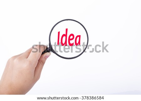 Hand showing IDEA word through magnifying glass. Isolated white, financial and business concept