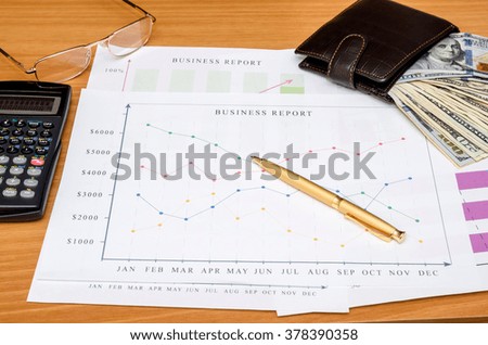 Graphs, charts, business table with money, calculator and pen on table