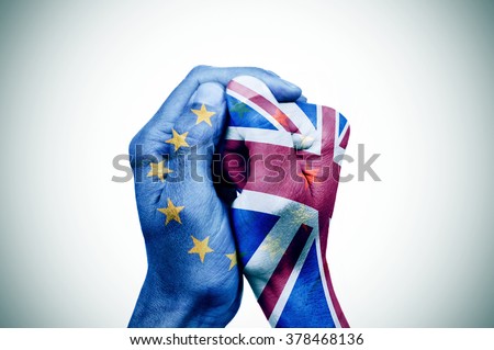 hand patterned with the flag of the European Community envelops another hand patterned with the flag of the United Kingdom Royalty-Free Stock Photo #378468136