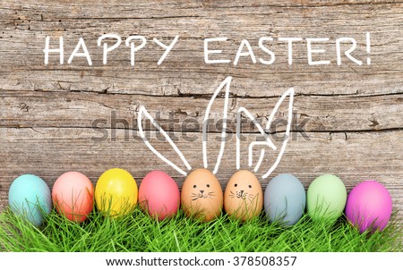 Easter eggs and cute bunny in green grass. Festive decoration. Happy Easter!