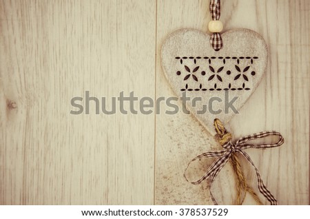 Decorative wooden heart on a wooden background.