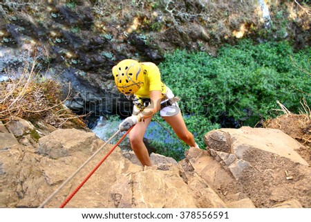 Climber rappelling on forested mountain slope with the evergreen conifers in a scenic summer landscape view. Royalty-Free Stock Photo #378556591